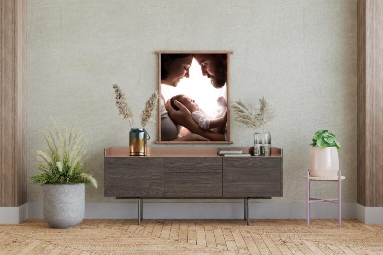 A framed photo of a couple holding a baby in a living room.
